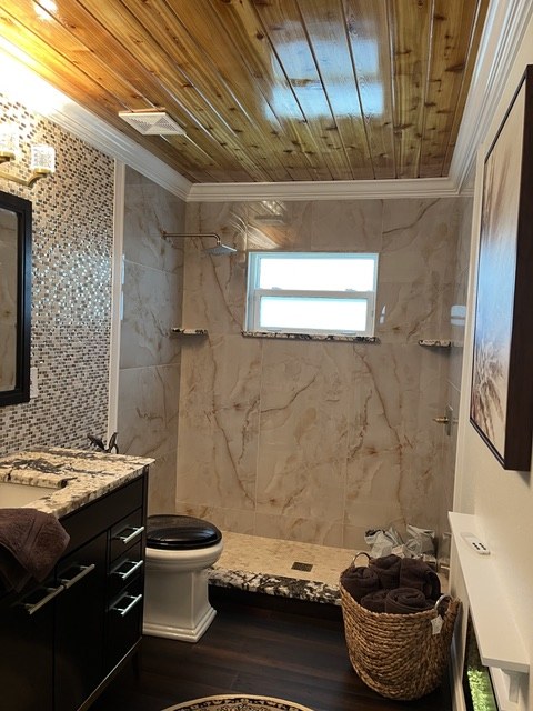 Bathroom with arched alcove shower, marble tile walls, and freestanding tub