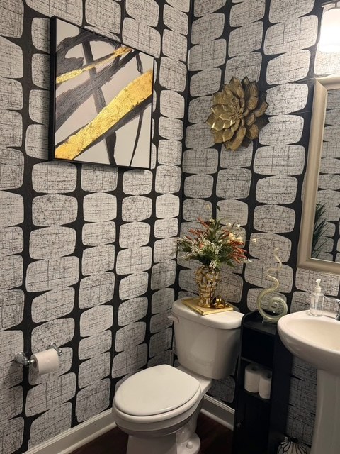 Bold black and white pattern wallpaper in a powder room with pedestal sink installed by Jeff Handyman