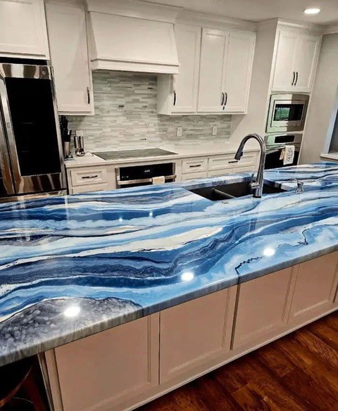 Kitchen with vivid blue marble waterfall countertop and dark cabinetry by Jeff Handyman