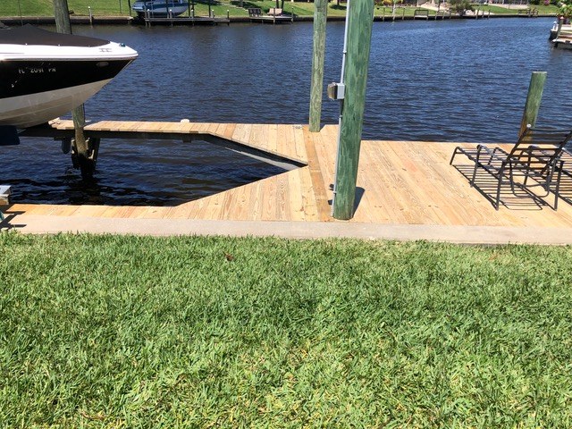 Completed boat dock rebuild with new wood decking on a Palm Coast canal by Jeff Handyman
