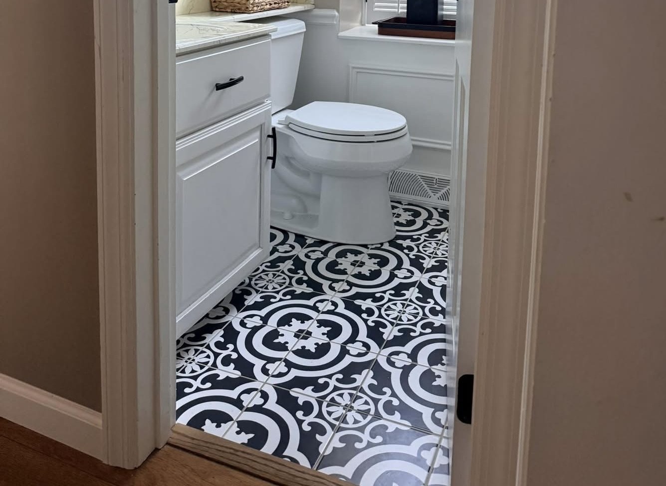 Bathroom with bold black and white encaustic pattern tile floor by Jeff Handyman