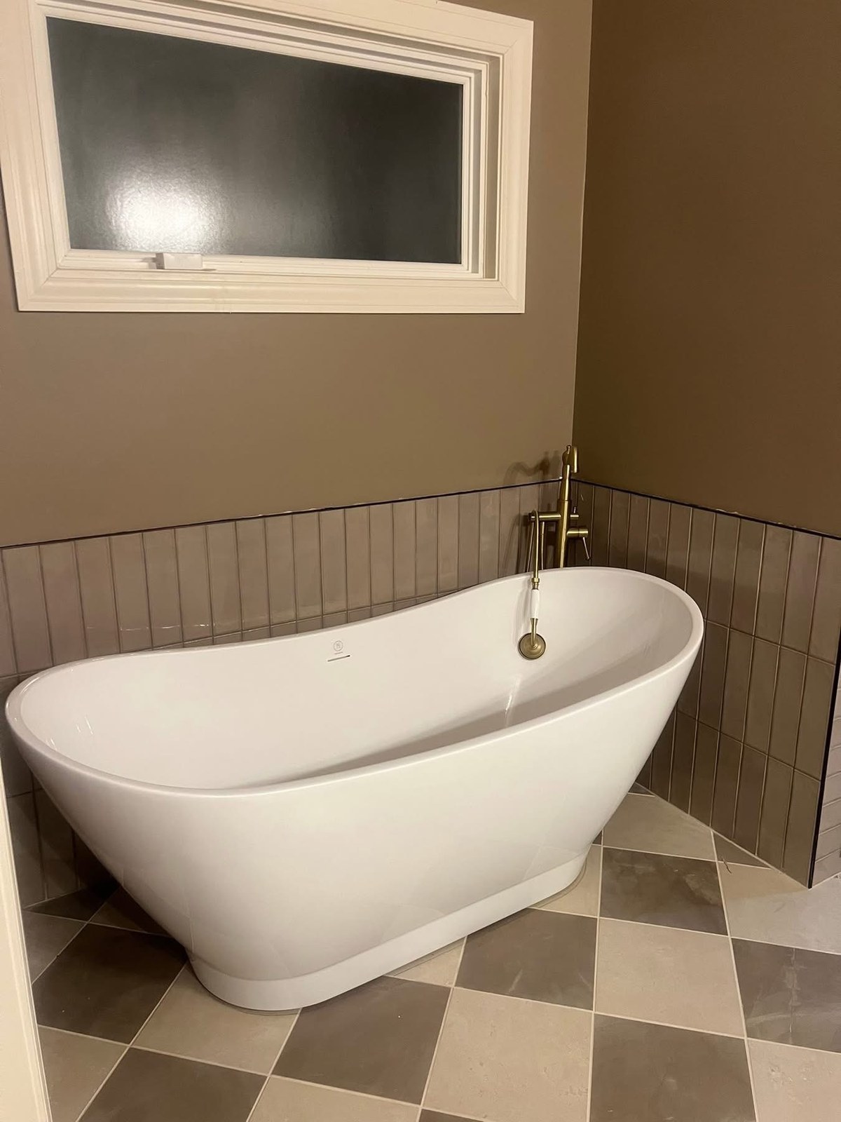 Bathroom with classic checkerboard tile floor and freestanding soaking tub by Jeff Handyman