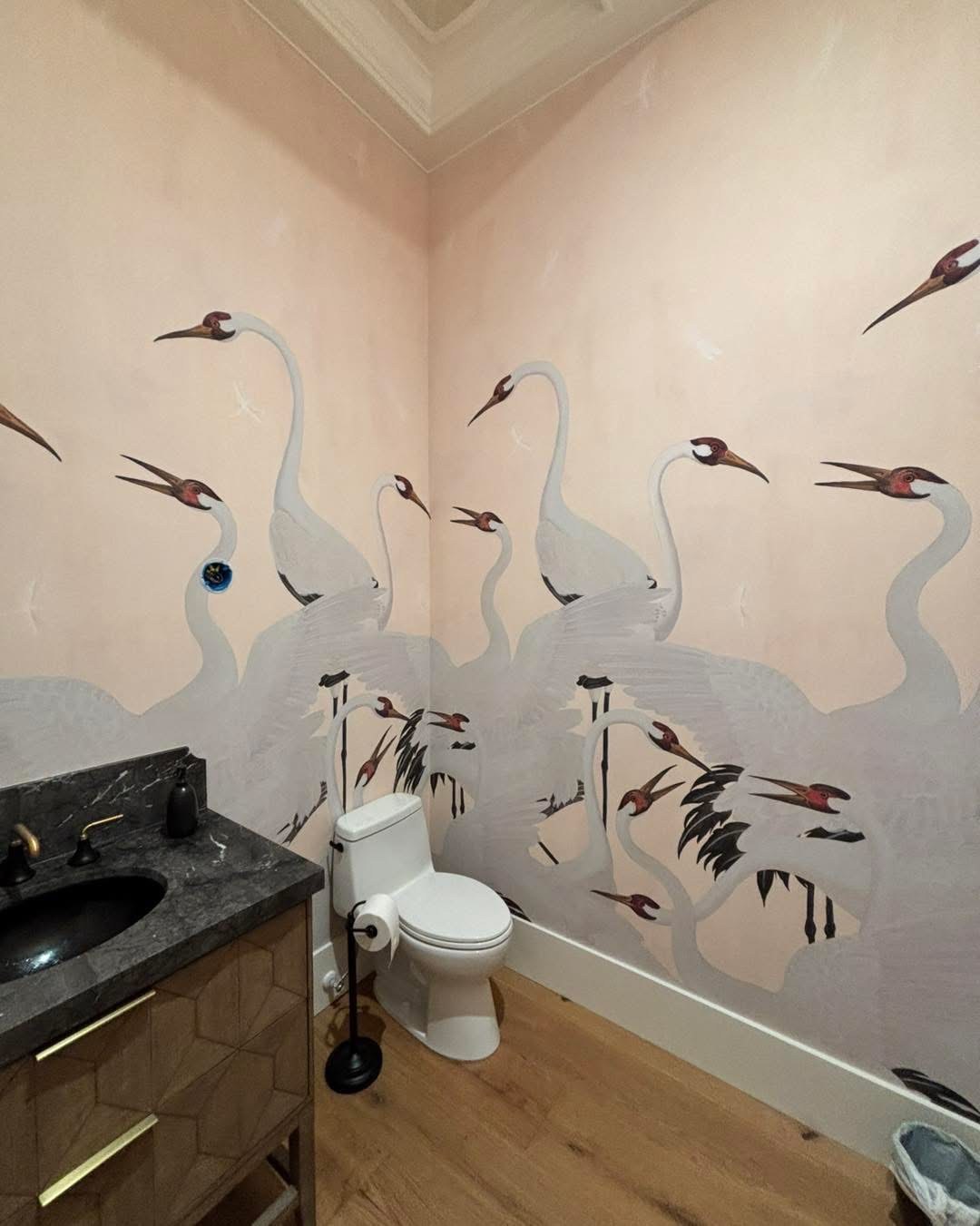 Hand-painted style crane mural wallpaper on blush walls in a powder room installed by Jeff Handyman