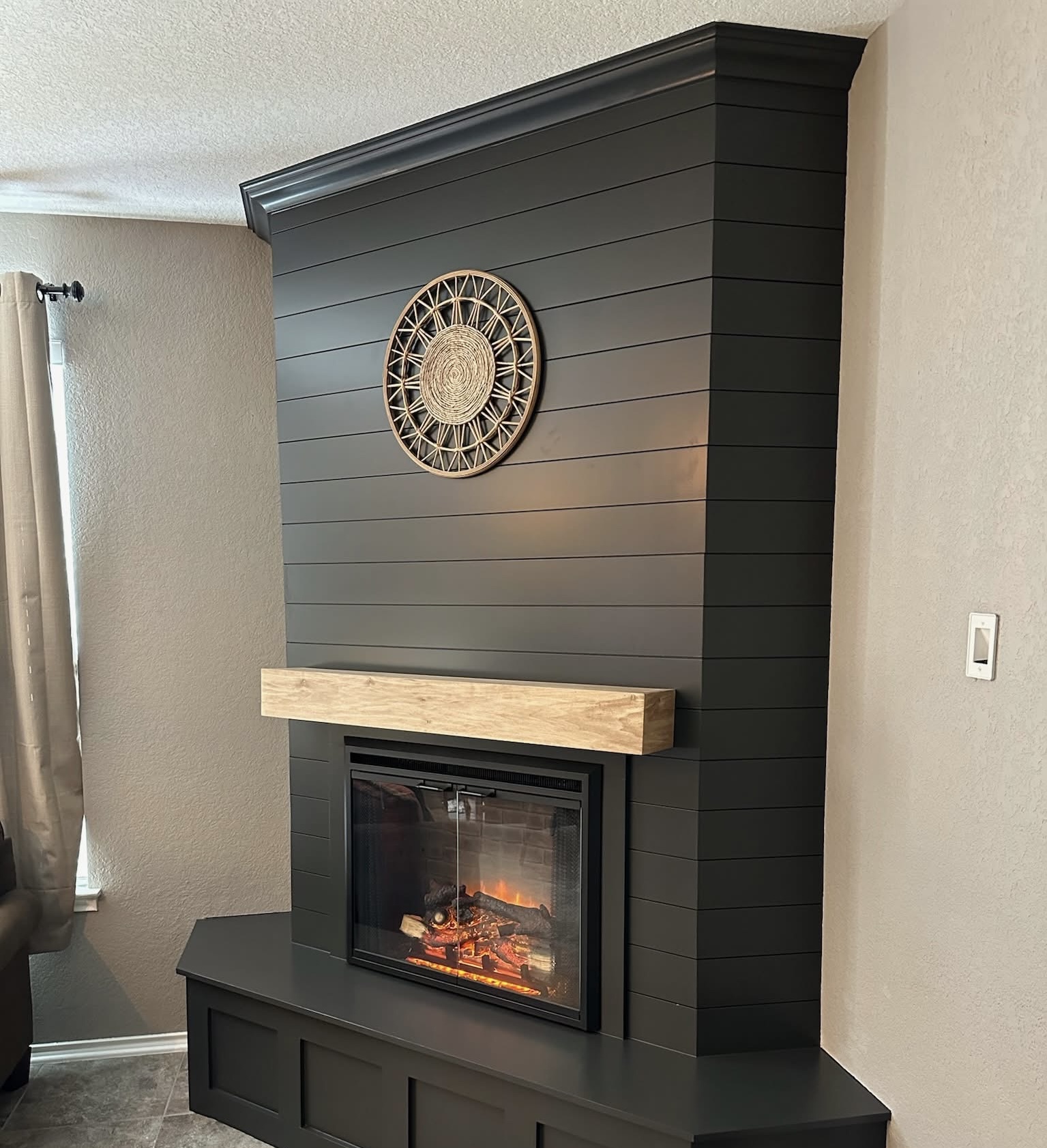 Black shiplap fireplace feature wall with reclaimed wood mantel