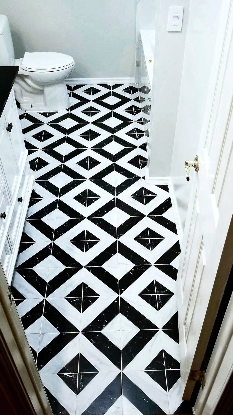 Bold black and white diamond grid pattern tile floor in a Palm Coast entry hallway by Jeff Handyman