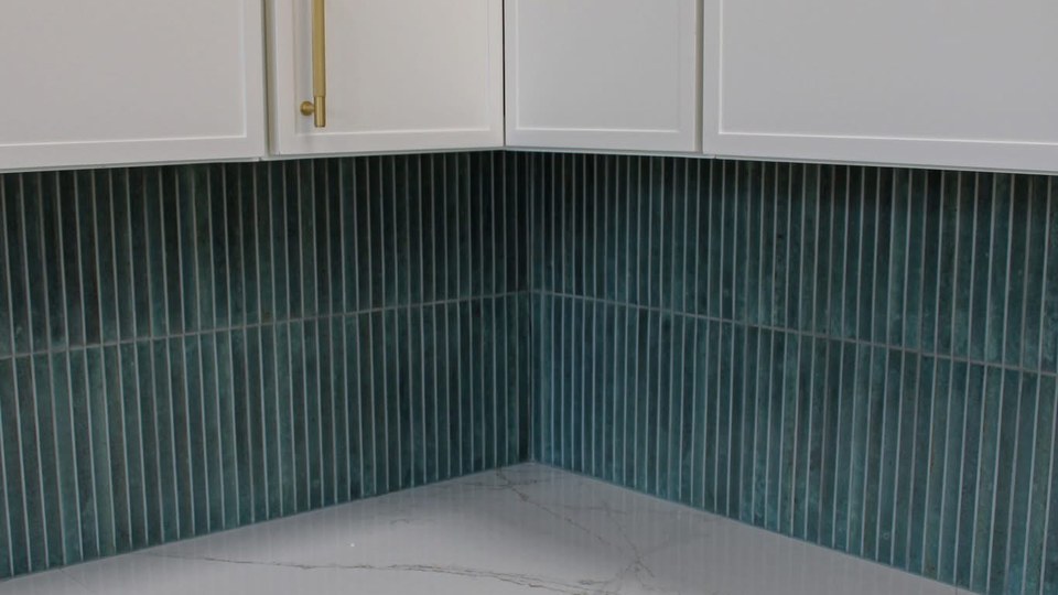Emerald green fluted tile kitchen backsplash with brass pulls
