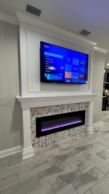 Living room TV accent wall with linear fireplace and floating walnut shelves