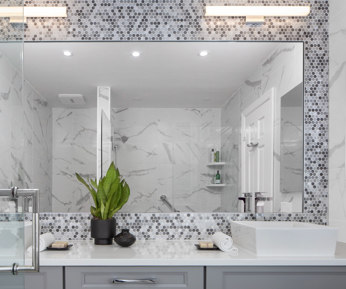 Mosaic tile wall behind a bathroom mirror