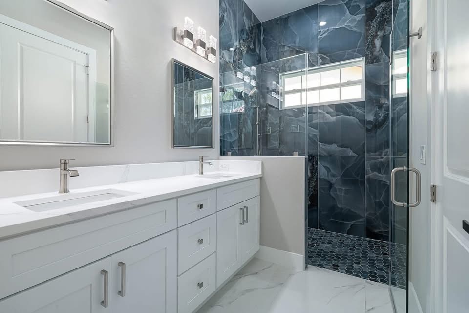 Navy marble tile shower with glass doors and double vanity, built by Jeff Handyman in Palm Coast, Florida