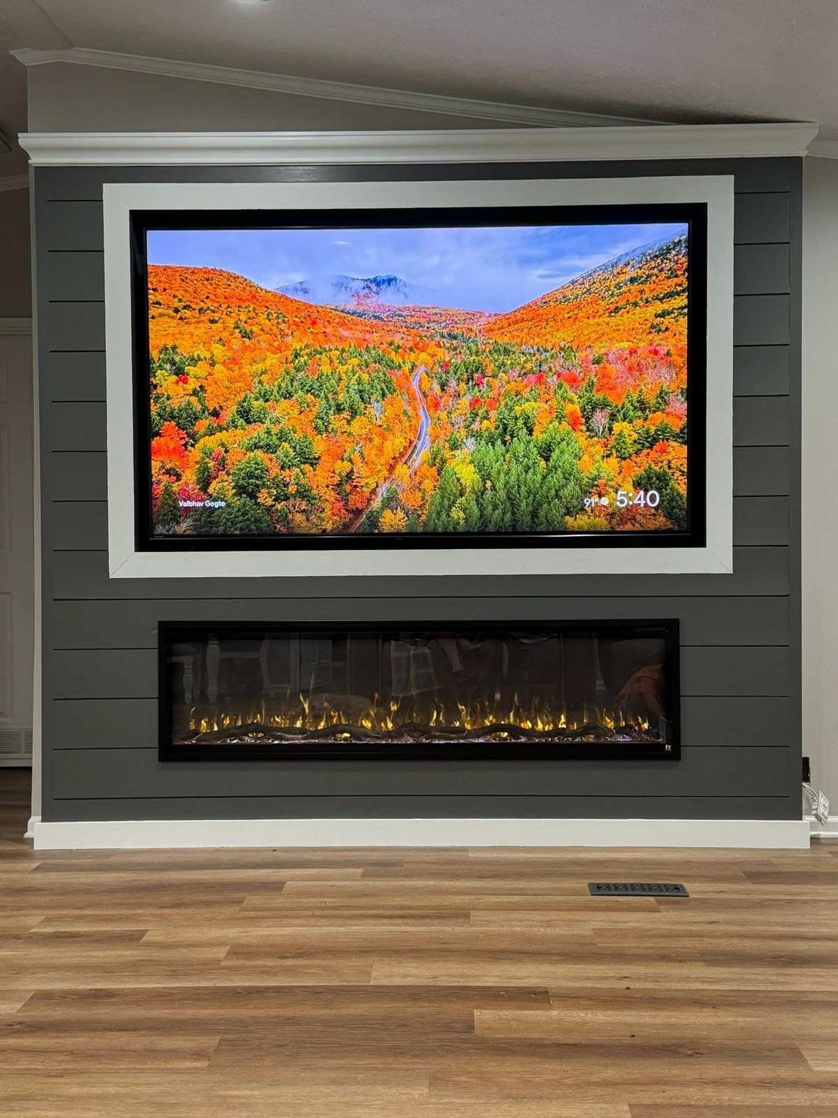 Gray shiplap TV and fireplace wall with linear electric fireplace and white framed TV recess
