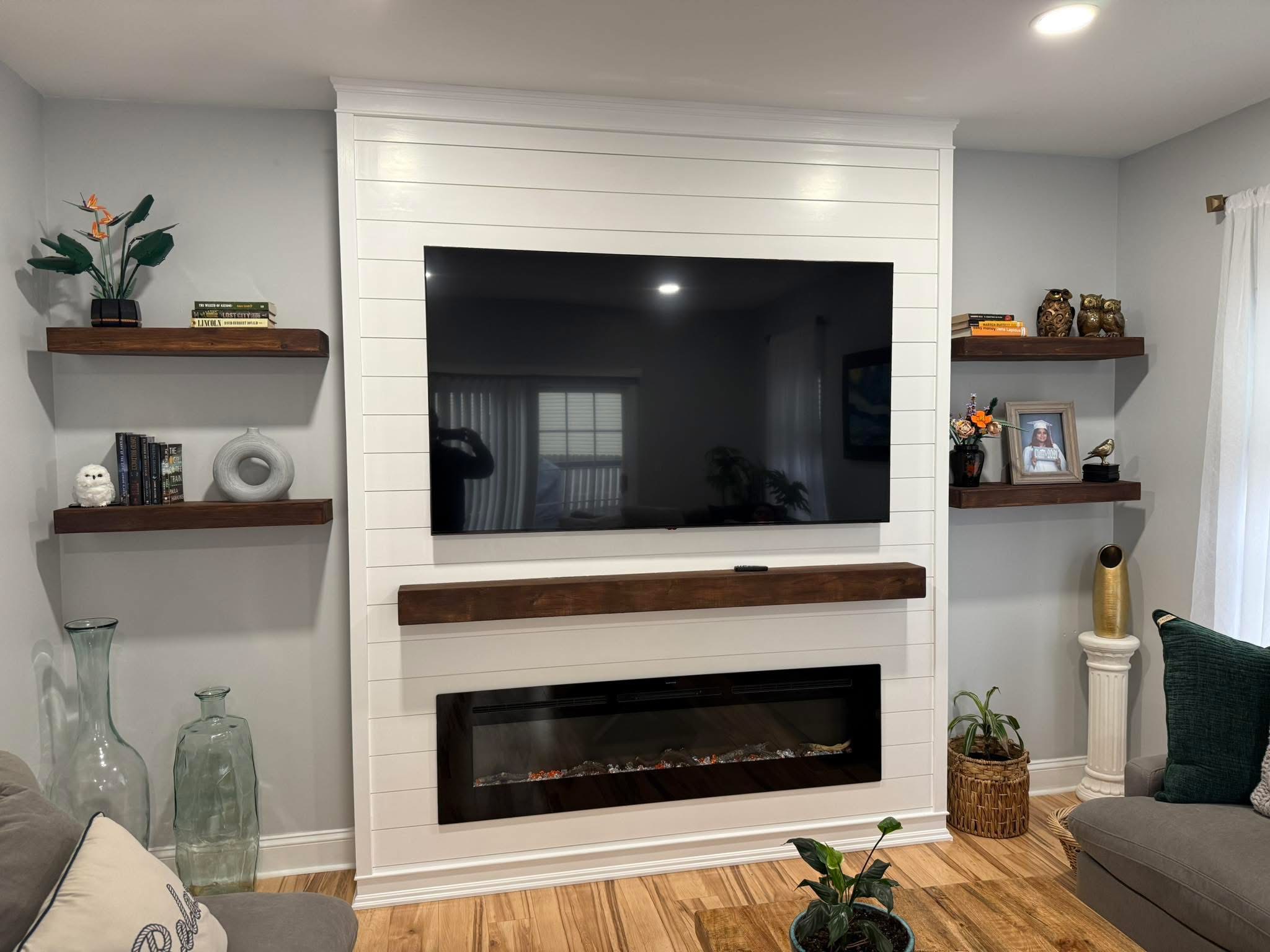 Custom white shiplap fireplace wall with mounted TV and floating walnut shelves