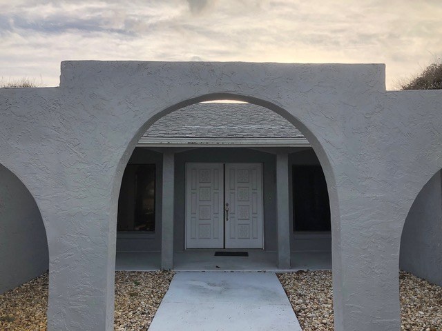 Same stucco arched doorway after Jeff Handyman patched and refinished the wall