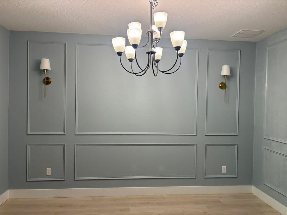 Sage blue wainscoted dining room with chandelier